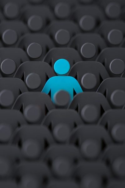 picture of a monochrome audience with one person highlighted in blue